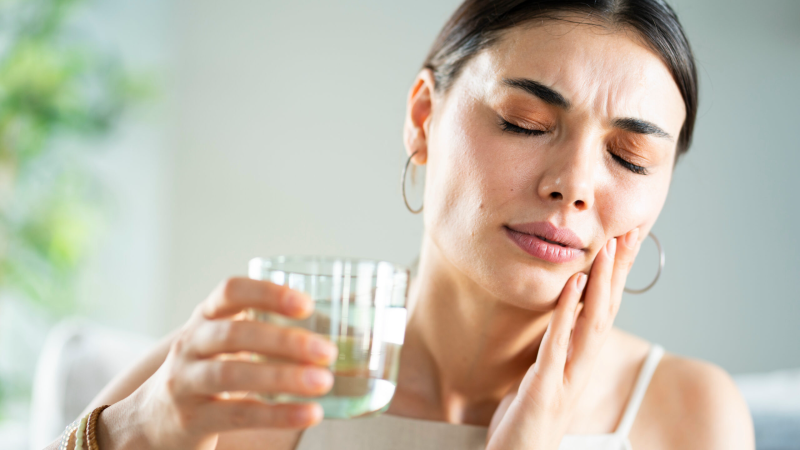 person holding mouth mirror examining oral mucosa