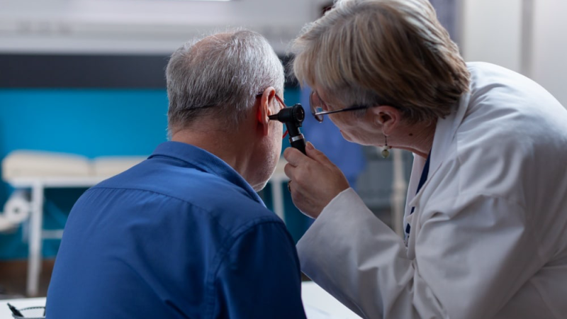 person experiencing sudden hearing loss touching ear in distress