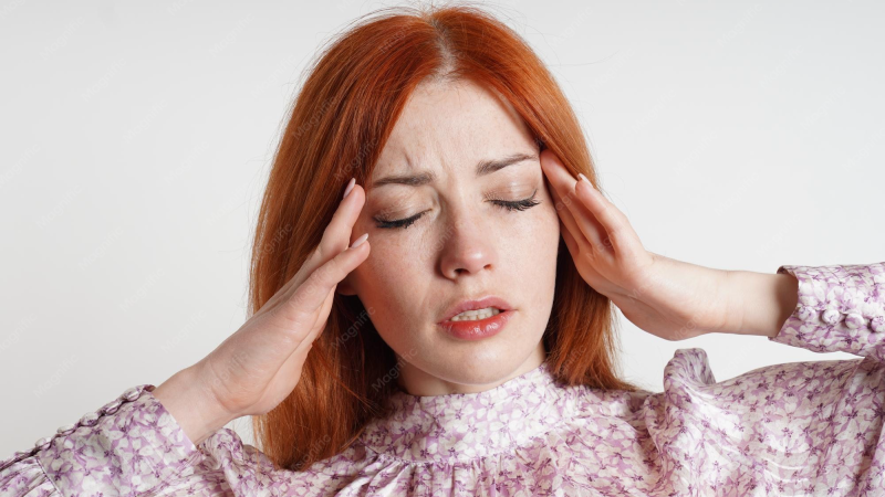 person rubbing temples with frustrated expression