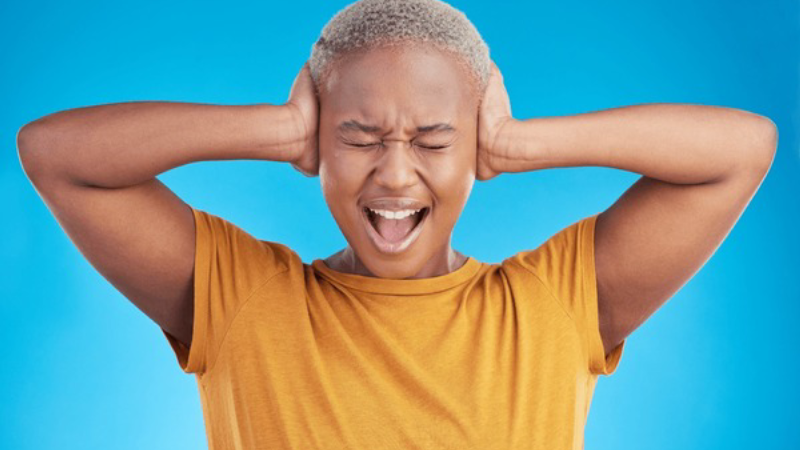 frustrated person holding ears, tinnitus concept