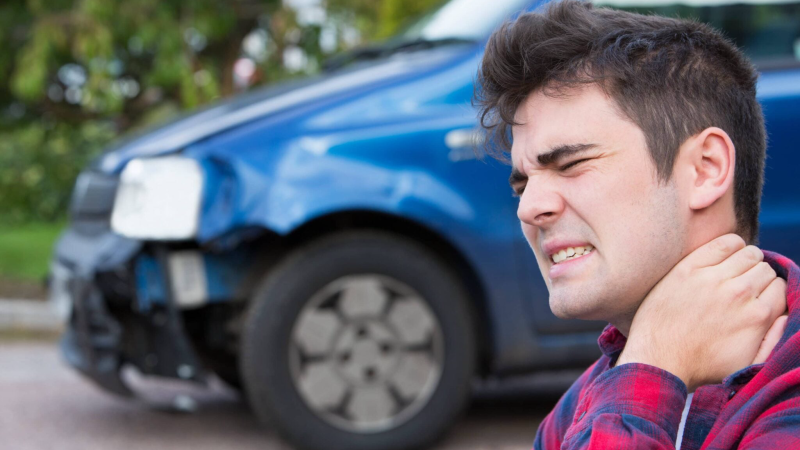 person holding neck after car accident