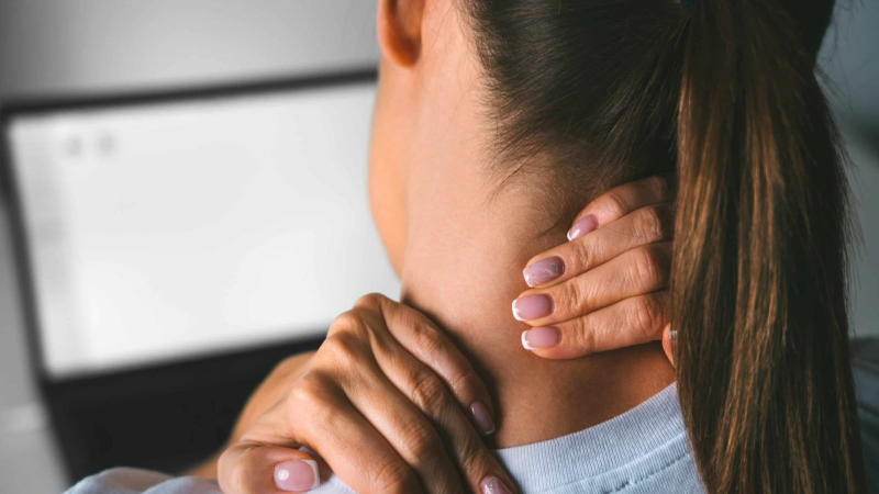 person massaging jaw and neck in pain