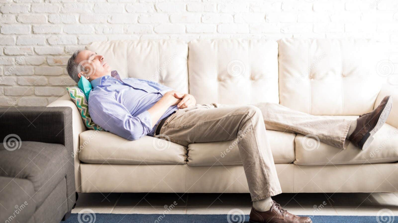 middle-aged man sitting on couch looking tired
