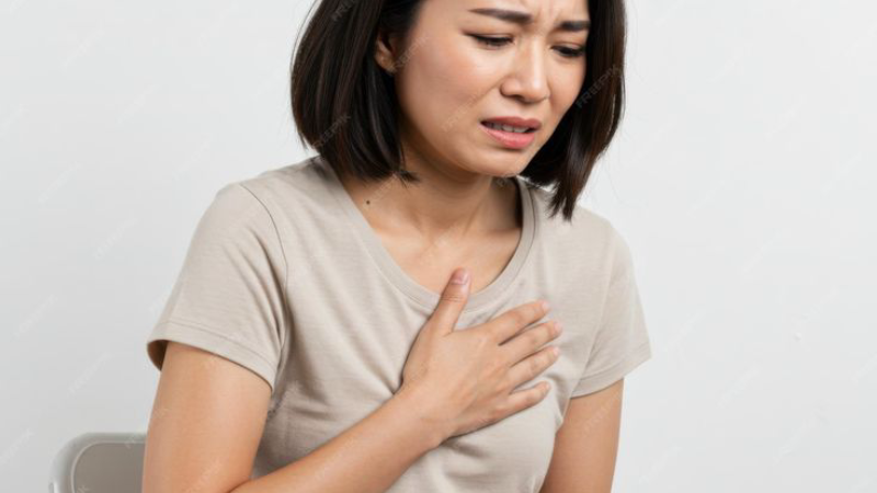 person suffering from shortness of breath holding chest