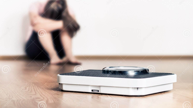 middle-aged woman looking frustrated at bathroom scale