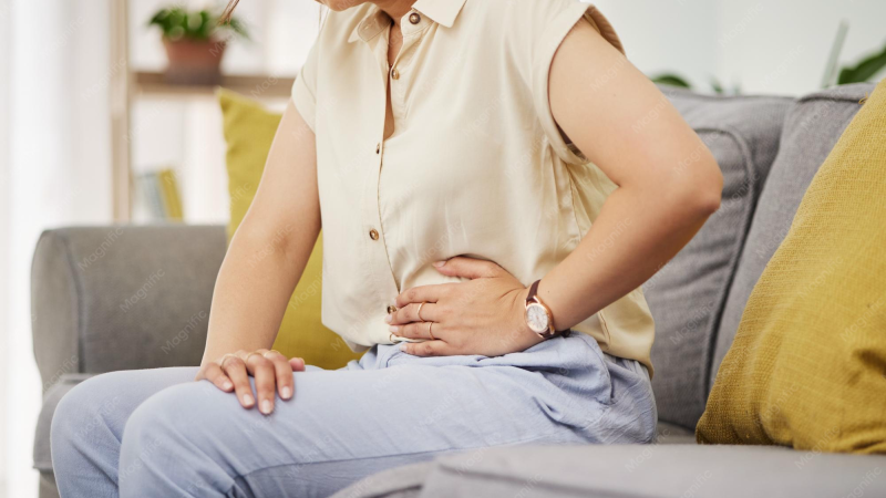 woman holding abdomen with bloating PMS symptom