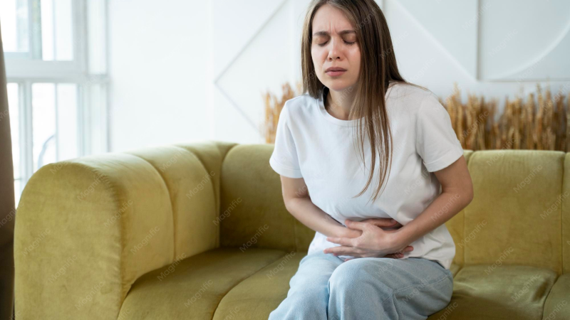 woman holding abdomen in pain, PMS concept