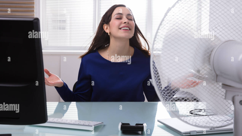 woman feeling hot flash in office